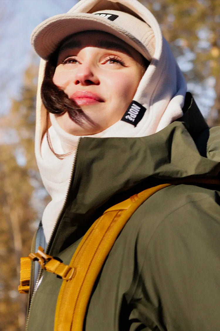 femme en randonnée automnale portant une capuche et une casquette nopé couleur crème