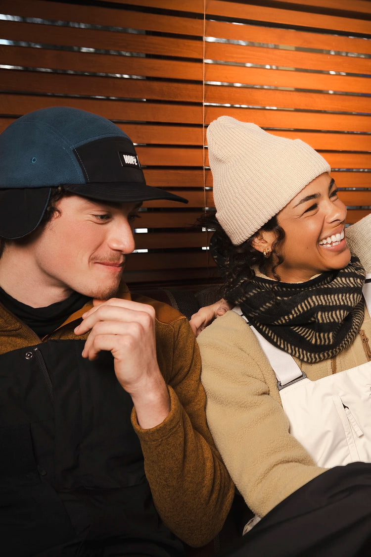 homme et femme assis portant une casquette trappeur et une tuque nopé