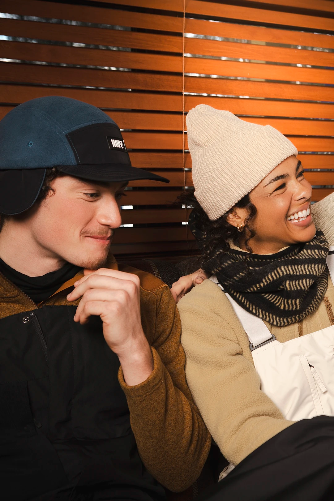 homme et femme assis portant une casquette trappeur et une tuque nopé
