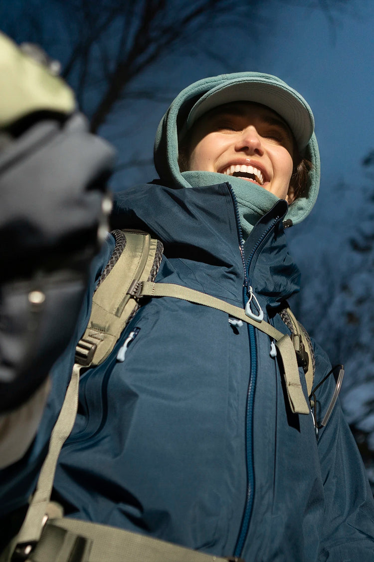 femme en randonnée hivernale portant une casquette polaire et une capuche nopé