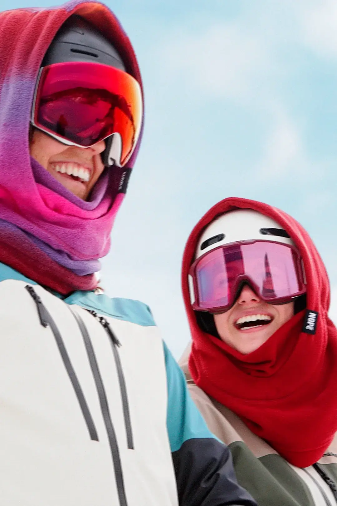deux femmes en ski portant des surcapuches nopé