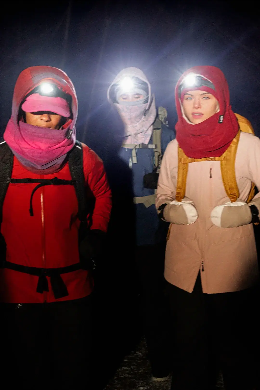 trois femmes en randonnée hivernal le soir portant les capuches nopé