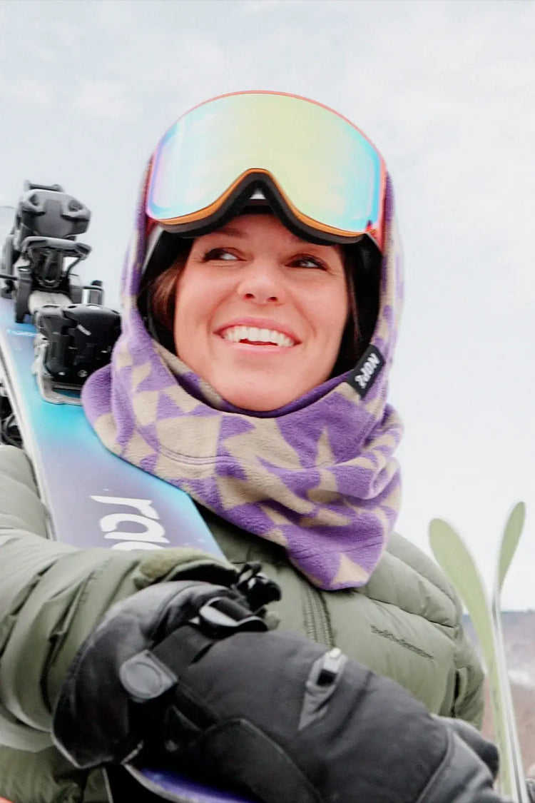femme tenant ses skis portant une surcapuche nopé de couleur étoile mauve