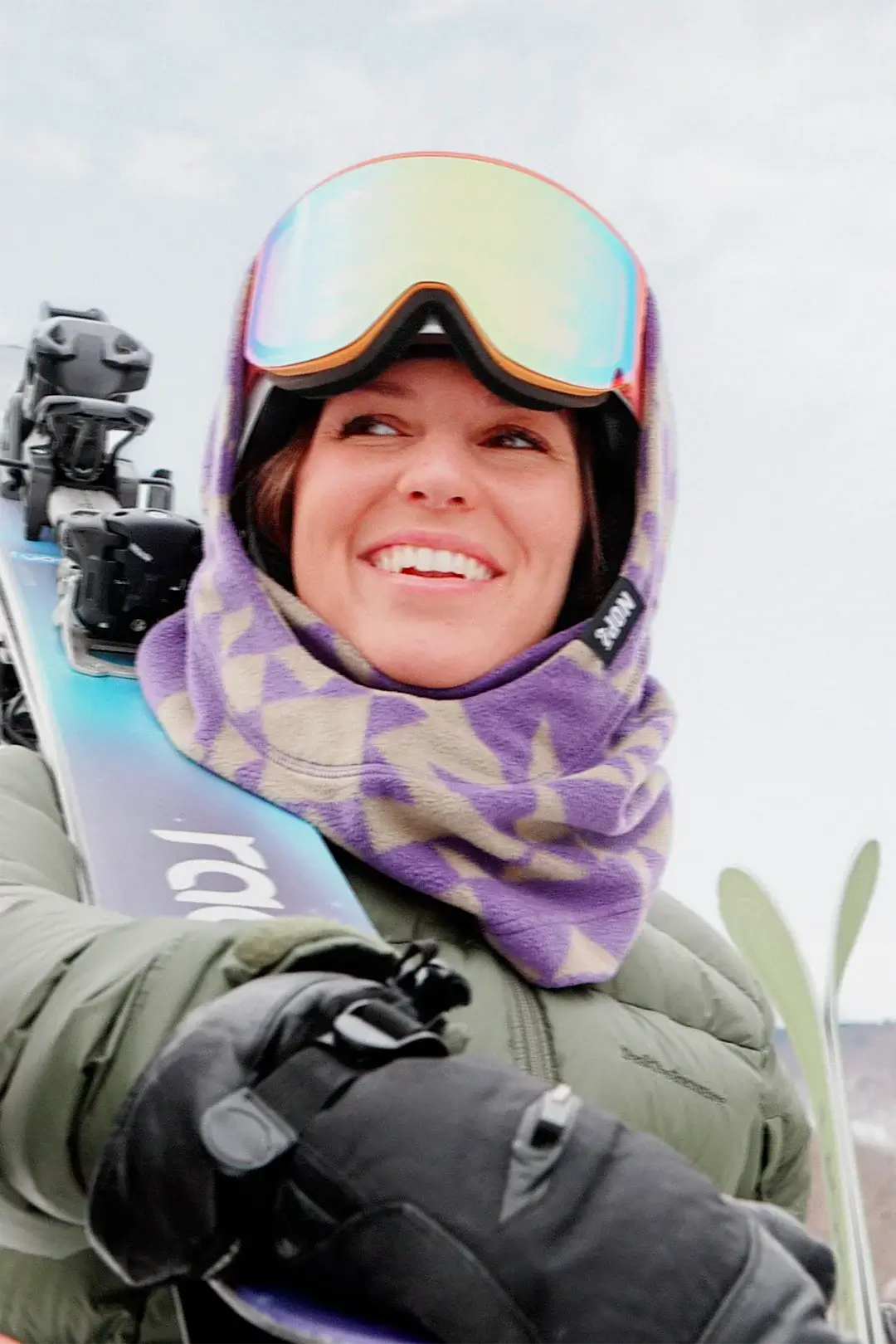 femme tenant ses skis portant une surcapuche nopé de couleur étoile mauve