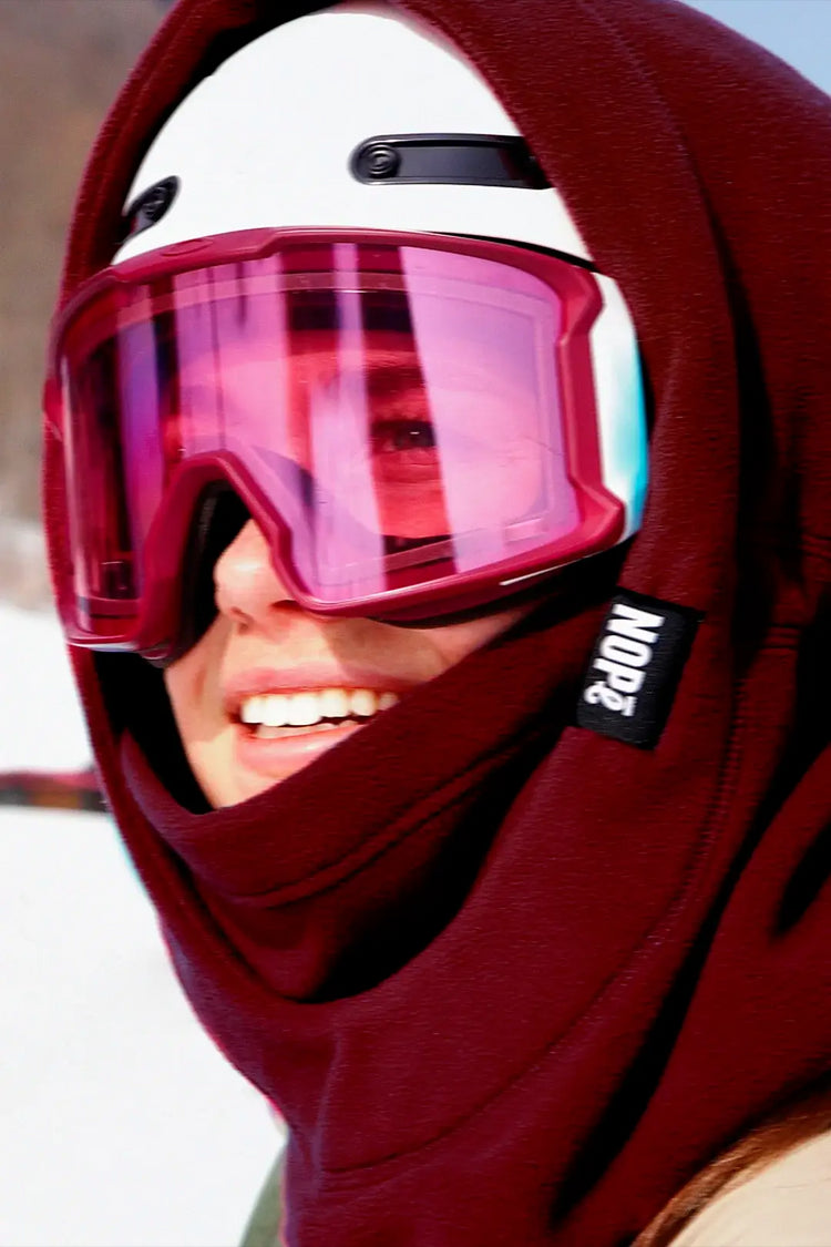femme en ski avec une surcapuche nompé de couleur minerai