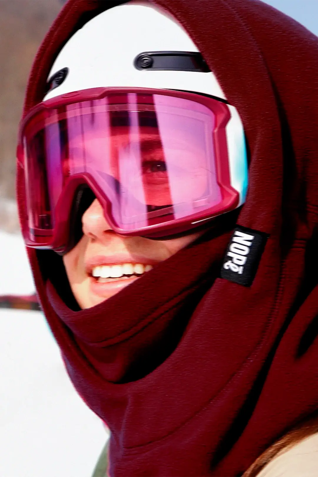 femme en ski avec une surcapuche nompé de couleur minerai